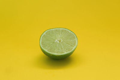 Close-up of lemon slice against yellow background