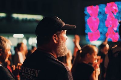 Midsection of man with arms raised at night