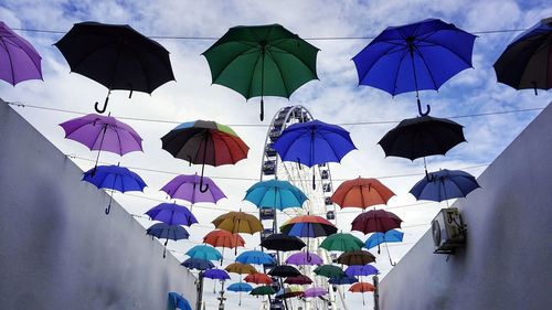 Low angle view of umbrellas hanging against sky