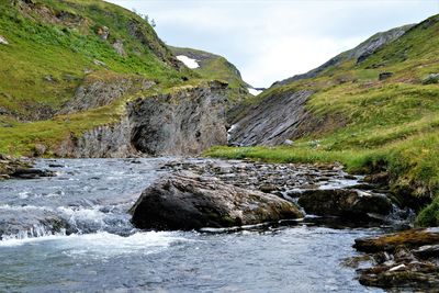 Scenic view of river amidst rocks against sky