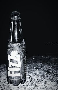 Close-up of glass bottle against black background