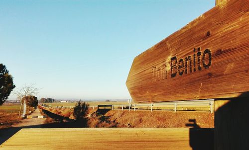 Text on wooden wall against clear sky