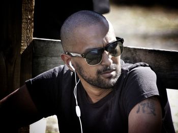 Young man looking away while listening music