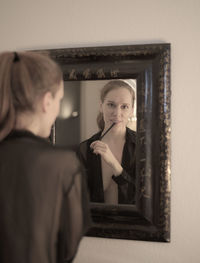 Portrait of woman with reflection in mirror