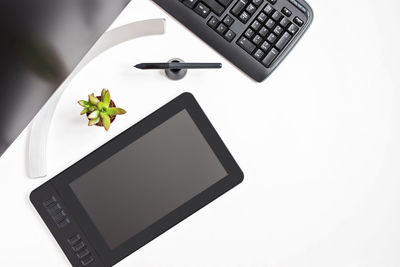 High angle view of laptop and calculator on white background