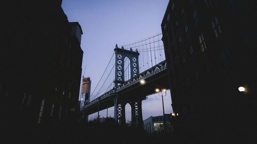 Low angle view of manhattan bridge against sky in city