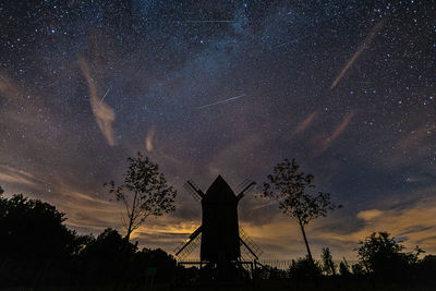 Low angle view of silhouette trees against sky at night