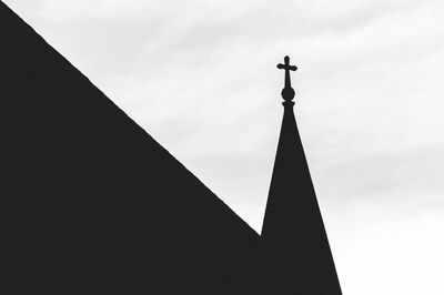 Low angle view of silhouette cross on church against sky