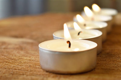 Close-up of tea light candles on table at home