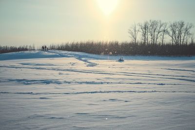 Scenic view of snow field against sky during winter