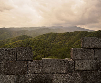 View of stone wall against cloudy sky