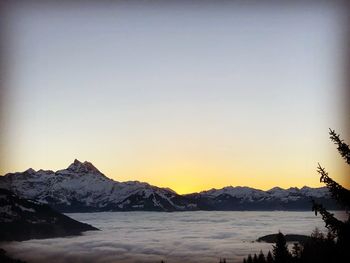 Scenic view of snowcapped mountains against sky during sunset