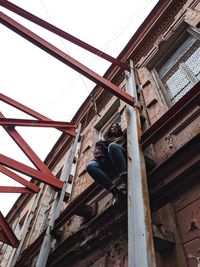 Low angle view of man sitting on ceiling