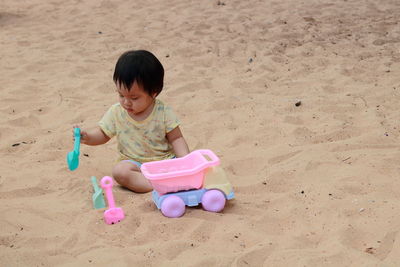Girl playing with toy on beach