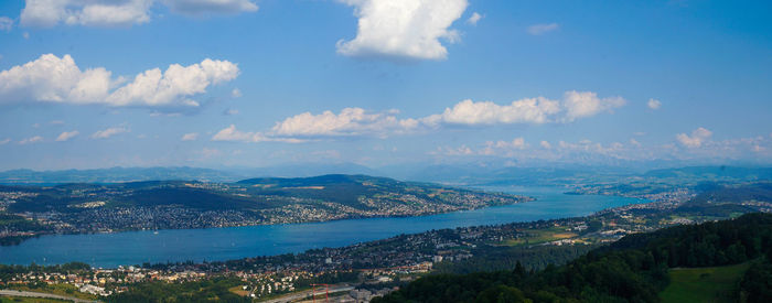 Aerial view of city by sea against sky