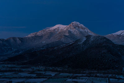 Scenic view of snowcapped mountains against blue sky