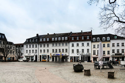 Houses by street in town against sky