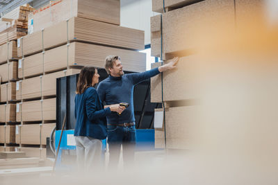 Architects examining wooden planks standing in industry