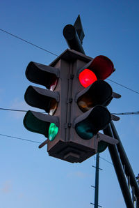 Low angle view of road signal against clear blue sky