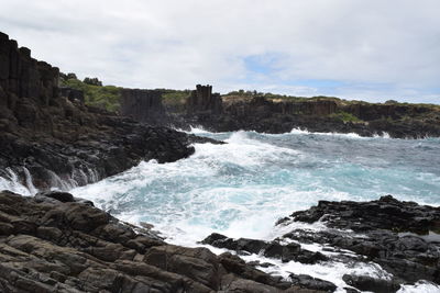 Scenic view of rocks in sea against sky