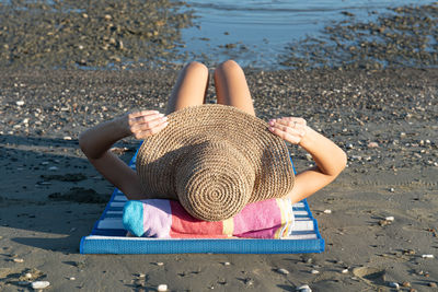 Midsection of woman sitting on beach