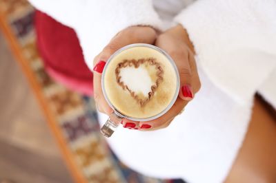 Midsection of woman holding cappuccino