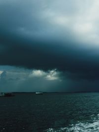 Scenic view of sea against storm clouds