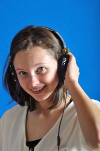 Portrait of smiling young woman against blue sky