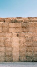 Hay bales on field against clear sky