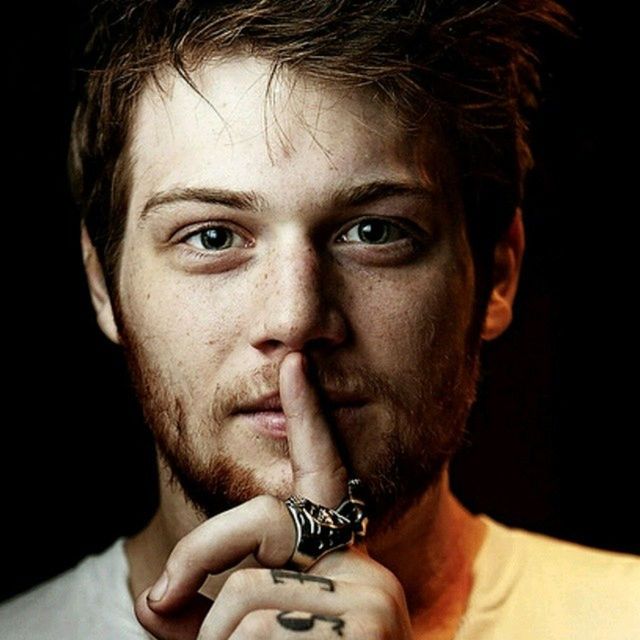 person, looking at camera, headshot, indoors, portrait, lifestyles, young adult, studio shot, front view, young men, close-up, black background, leisure activity, human face, mid adult, serious, head and shoulders, mid adult men