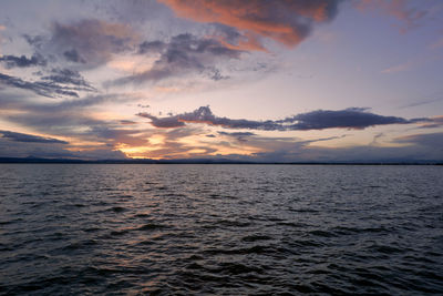 Landscape of a lake with storm clouds, moving waters reeds in the water, bluish tones