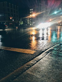 Illuminated city street against sky at night