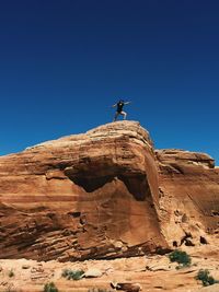 Low angle view of man against clear blue sky