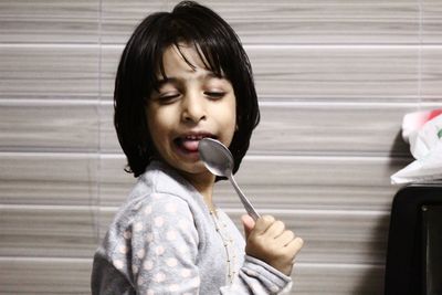 Portrait of woman holding while sitting on floor