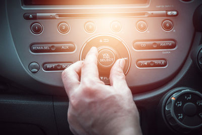 Cropped hand of man playing music in car