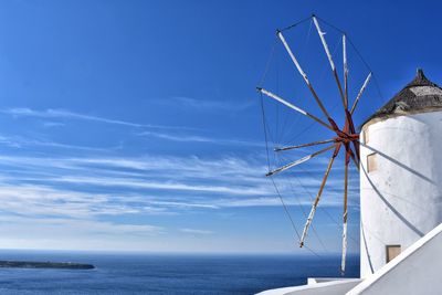 Ferris wheel by sea against sky