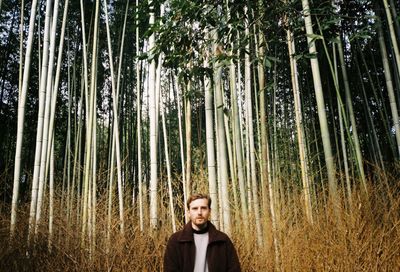 Portrait of man standing amidst bamboo trees in kyoto