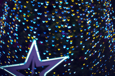 Low angle view of illuminated christmas lights against sky at night