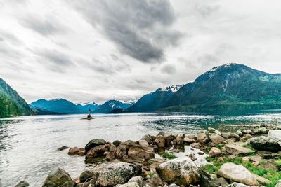 Scenic view of lake by mountains against sky