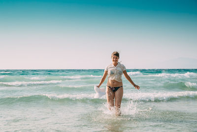 Rear view of woman standing at beach