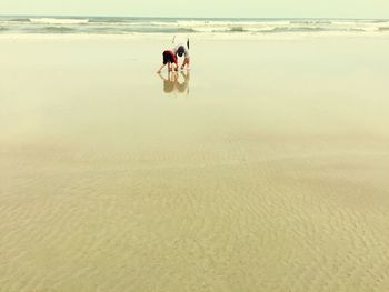 Father and son standing on beach