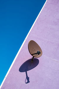 Low angle view of pink umbrella against blue sky