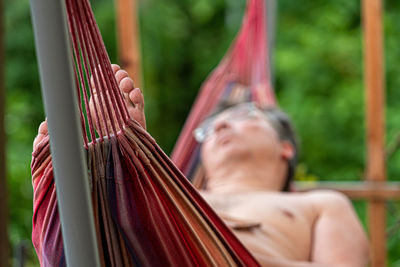 Man is chilling and relaxing in the hammock, selective focus, focus on the feet