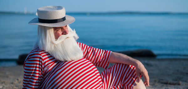 Midsection of woman wearing hat on beach