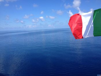 Italian flag waving against sea