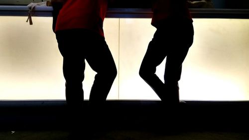 Low section of silhouette man standing in bus