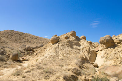 Rock formations in desert against clear blue sky