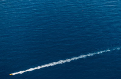 High angle view of vapor trails in sea