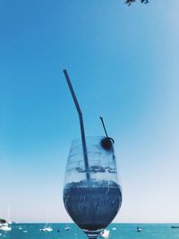 View of drink in sea against clear blue sky