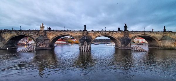 Arch bridge over river against sky